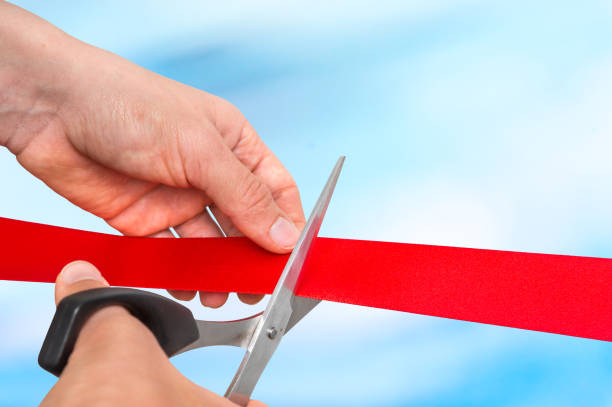 istock Hand with scissors cutting red ribbon - opening ceremony 865729566