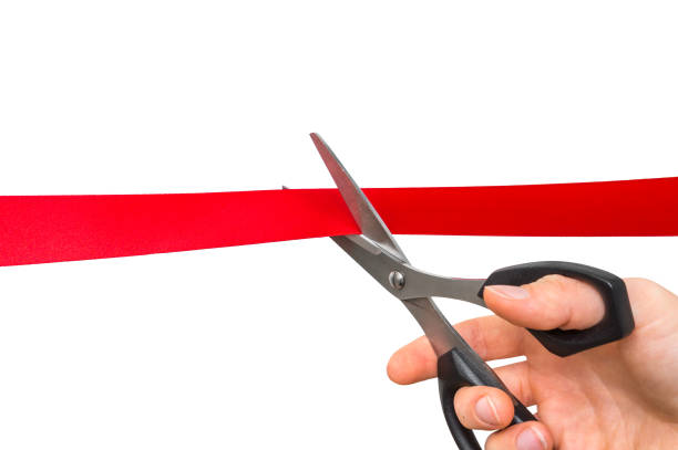 istock Hand with scissors cutting red ribbon - opening ceremony 865729610