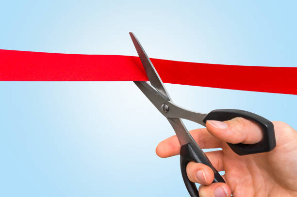 istock Hand with scissors cutting red ribbon - opening ceremony 865729836