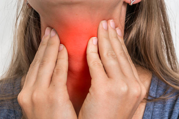 istock Woman with throat sore is holding her aching throat 865732092