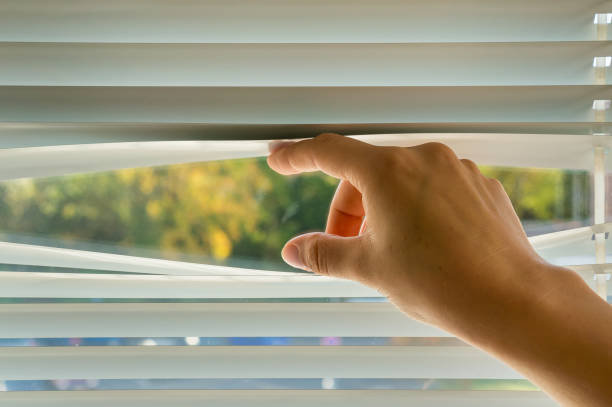 istock Woman is looking out through jalousie 865732284