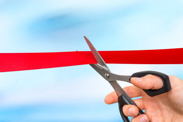 istock Hand with scissors cutting red ribbon - opening ceremony 865735386