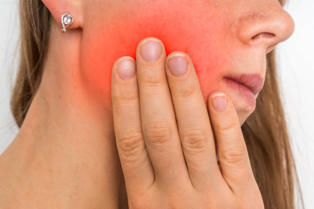 Woman with a painful expression is having toothache - body pain concept