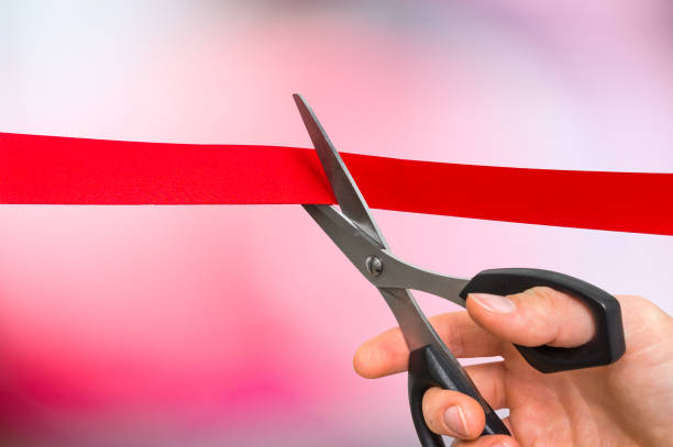 istock Hand with scissors cutting red ribbon - opening ceremony 865738064