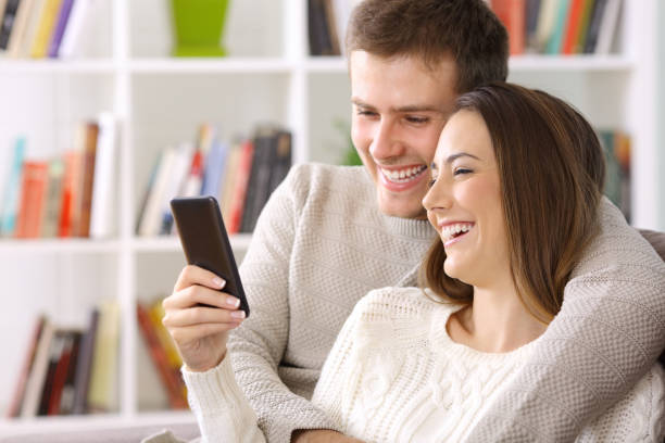 istock Couple using a smart phone at home in winter 865738726