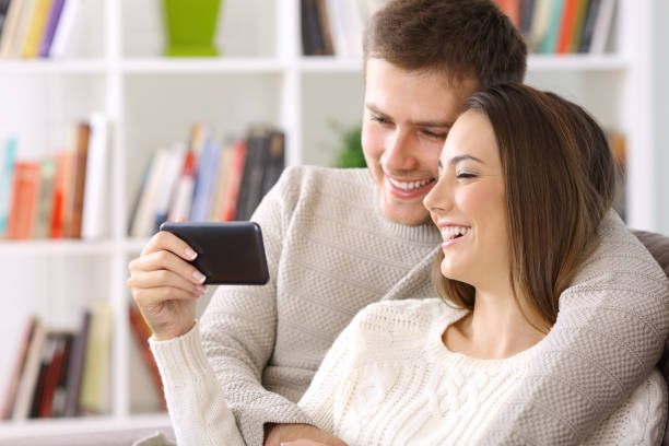 istock Couple watching on line content in a smart phone at home 865739066