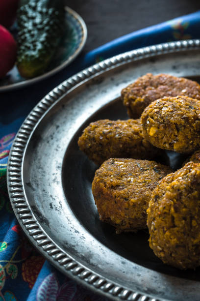 istock Falafel on a vintage tin plate and fresh vegetables side view 865745504