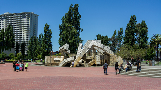 Tourists hang out at the plaza in front of Ferry Building. The water sculpture is currently dry.