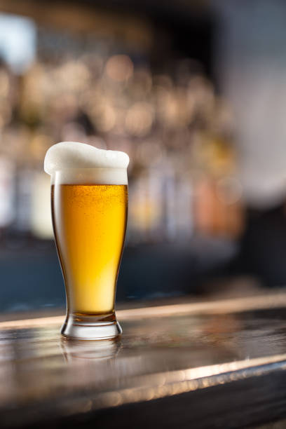 istock Glass of light beer on a dark pub 865750256
