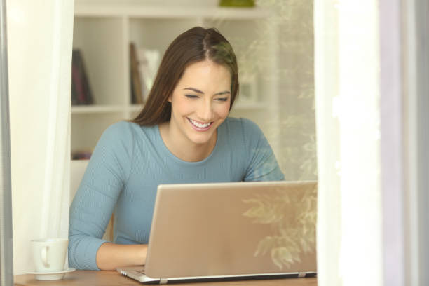 istock Girl using a laptop near a window at home 865753644