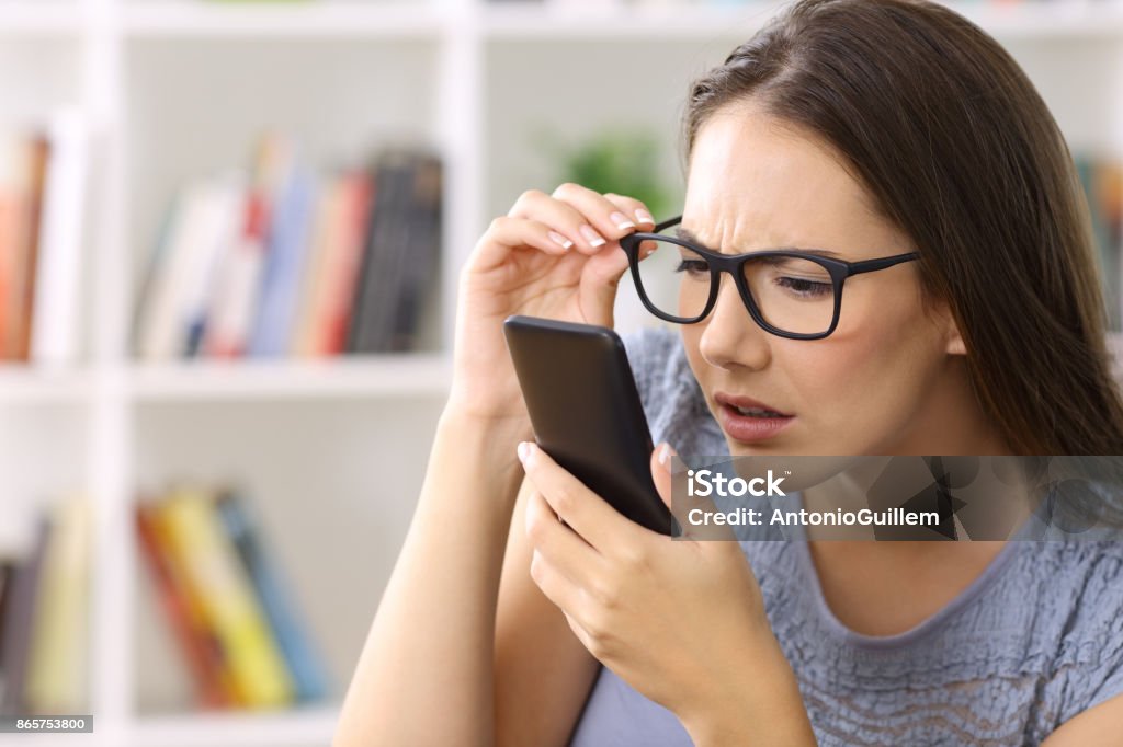 Mädchen mit Sehprobleme Telefon Text lesen - Lizenzfrei Problem Stock-Foto