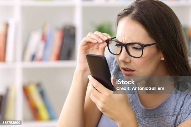Girl With Eyesight Problems Trying To Read Phone Text Stock Photo - Download Image Now
