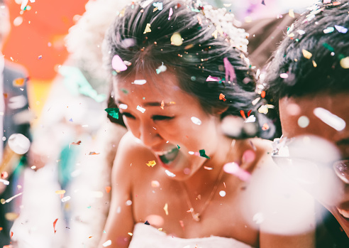 Wedding guests throwing petals to the bride and groom.