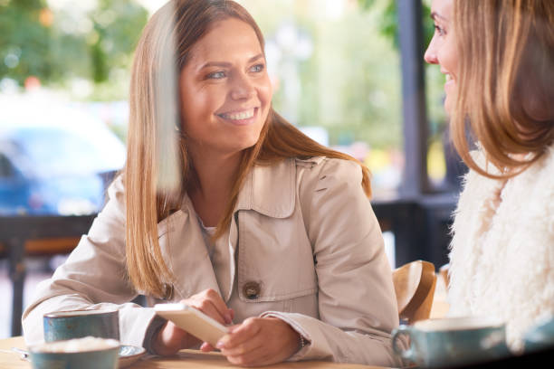 istock Modern ladies in sidewalk cafe 865757938