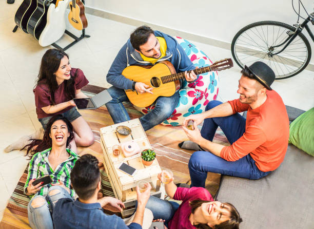 moda amigos divirtiéndose en la sala de estar casera - jóvenes felices disfrutar tiempo junto tocando música y tomar fotos - concepto de la amistad y la juventud - foco principal en la parte superior izquierda a chicos - filtro cálido - mid atlantic usa audio fotografías e imágenes de stock