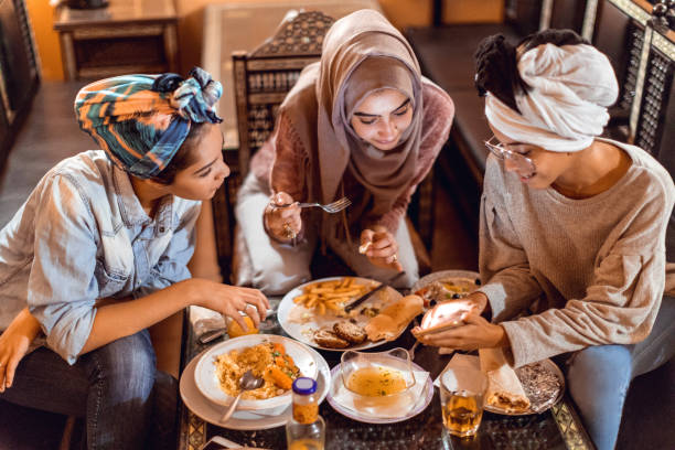 Muslim young women having a lunch break together in an Arab restaurant Muslim young women having a lunch break together in an Arab restaurant moroccan girl stock pictures, royalty-free photos & images