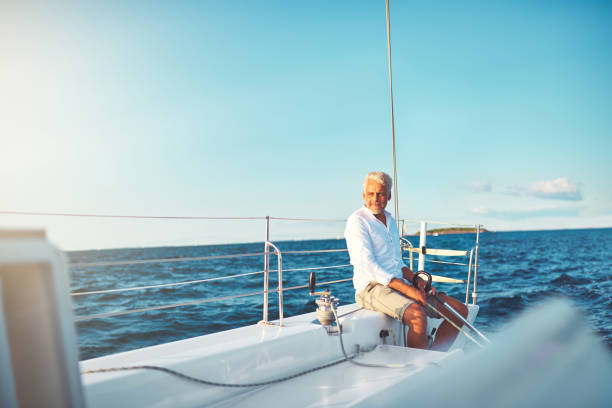 istock Mature man enjoying a sunny day sailing his boat 865767784