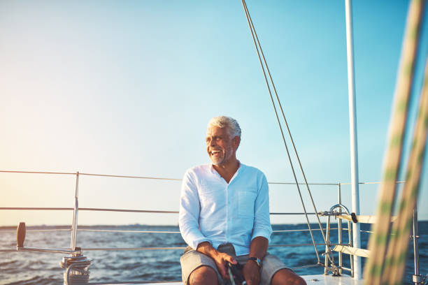 istock Mature man enjoying a sunny day sailing on the ocean 865768294