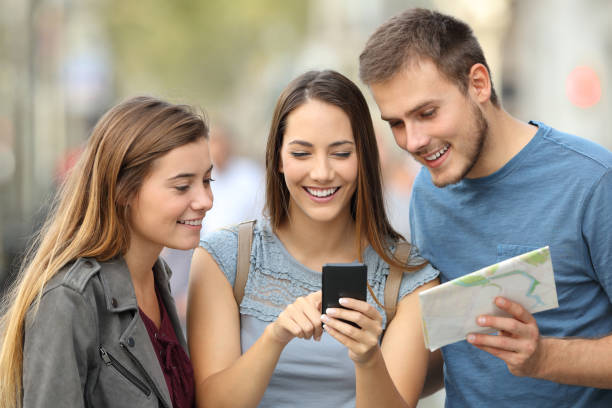 istock Three tourists checking location on the street 865768608
