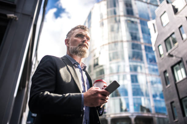 istock Businessman drinking coffee and using smart phone 865780004