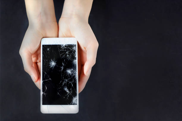 istock Girl holding a broken smart phone. 865780924