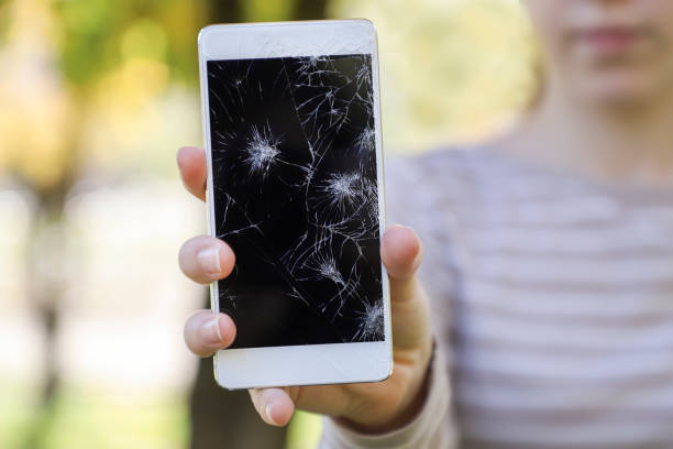 istock Girl holding a broken smart phone. 865781190