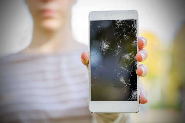 istock Girl holding a broken smart phone. 865781194