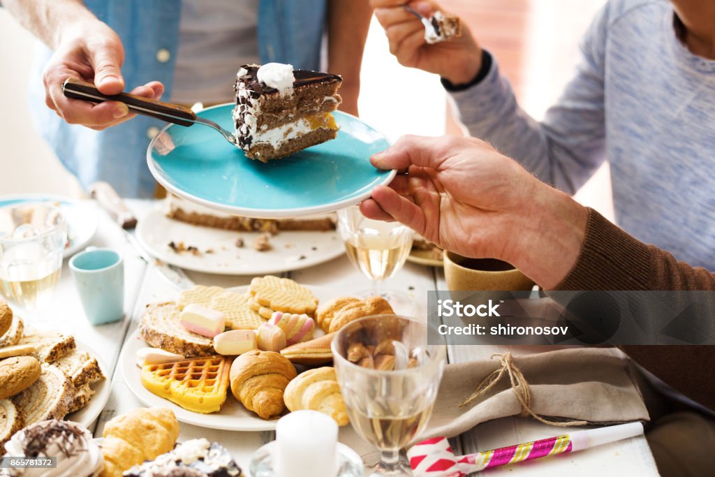 Yummy birthday cake Man putting piece of chocolate cake on saucer of one of guests at party Eating Stock Photo