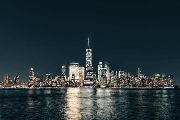 Lower Manhattan skyline, New York skyline at night Great night view of the famous skyline of Manhattan downtown district with many skyscrapers, whose lights reflects in the water. lower manhattan stock pictures, royalty-free photos & images