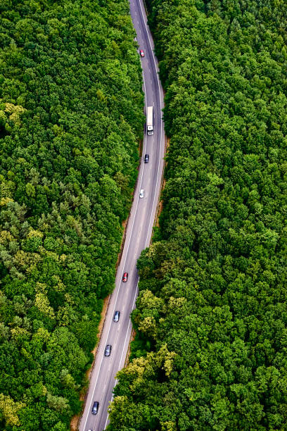 istock Aerial view over road with traffic going through forest landscape 865792504
