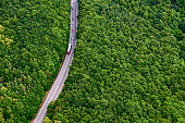 Aerial view over road with traffic going through forest landscape