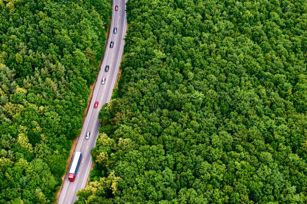 istock Aerial view over road with traffic going through forest landscape 865792744