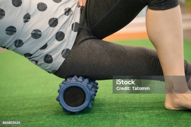 Woman Using A Foam Roll On Her Leg To Release Tension And Help With Muscle Pain In The Exercise Class Stock Photo - Download Image Now