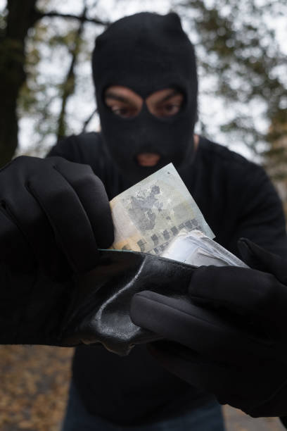 istock Unrecognizable sinister masked pickpocket stealing money from a wallet 865804814