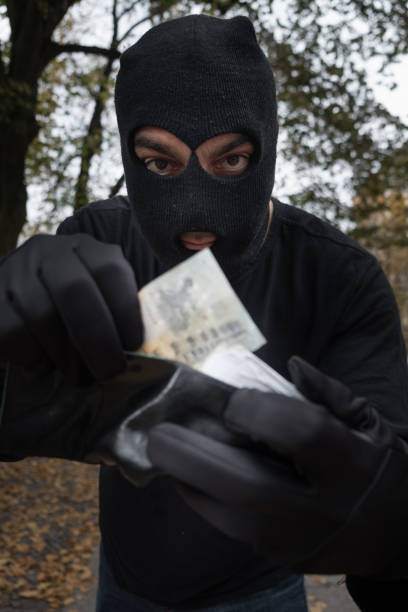 istock Unrecognizable sinister masked pickpocket stealing money from a wallet 865804842