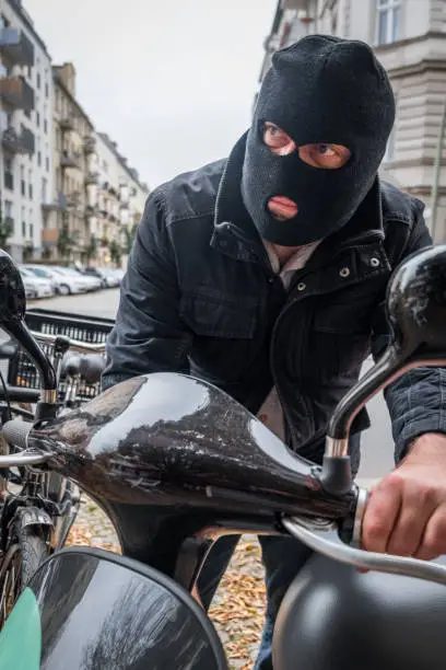 Photo of Theft wearing a balaclava stealing a scooter