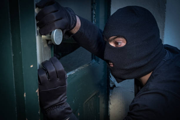 istock Burglar trying to force a door lock 865805054