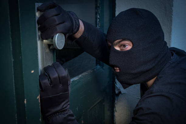 istock Burglar trying to force a door lock 865805056