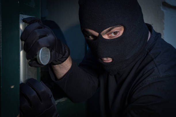 istock Burglar trying to force a door lock 865805074