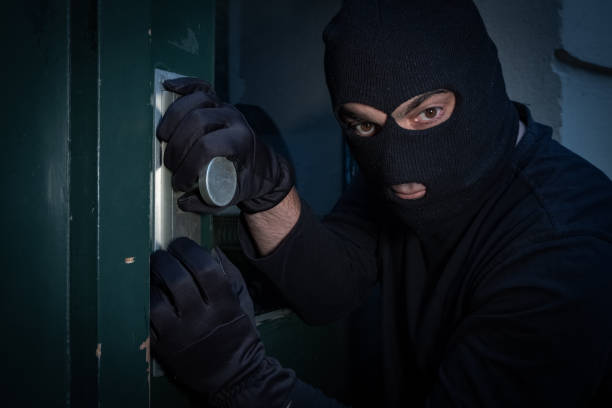 istock Burglar trying to force a door lock 865805102