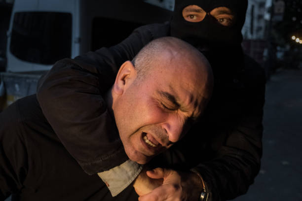 Burglar fighting with man outdoors at night