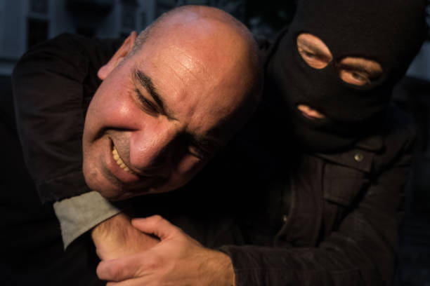 istock Burglar fighting with man outdoors at night 865805284