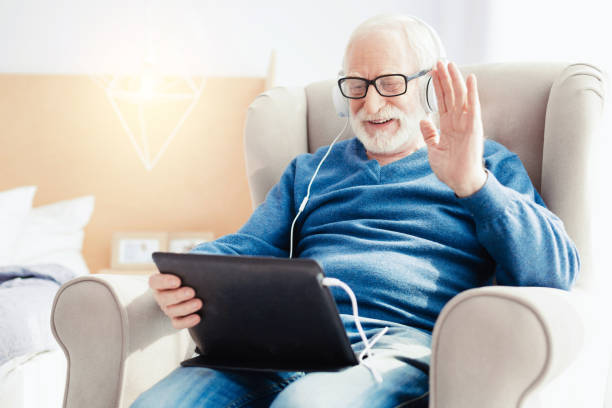 istock Happy senior male talking online 865806410