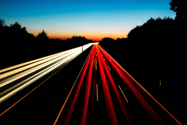 These light trails were captured from a bridge at night during a beautiful sunset. The sky and horizon was filled with blue and orange color.