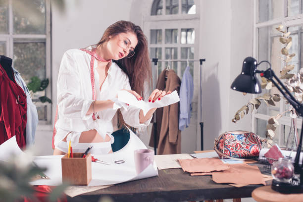 istock Fashion designers working in studio sitting on the desk 865807846