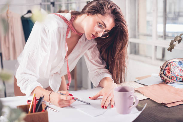 istock Fashion designers working in studio sitting on the desk 865808152