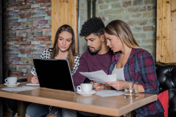 junge multi-ethnischen gruppe von menschen, die nachforschungen über darlehen für studierende - multi ethnic group reading stock-fotos und bilder