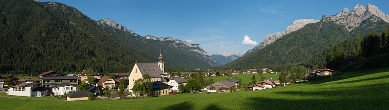 Panoramic view of a  Austrian mountain village with an onion shaped bell tower in the Tyrollean Alps.
