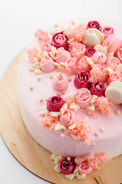 istock Pink glazed cake with cream flowers on white background 865820462