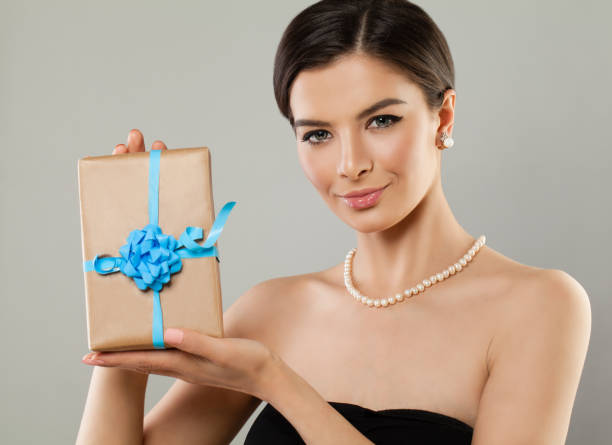 istock Fashion Model Woman with Gift on Background 865821428